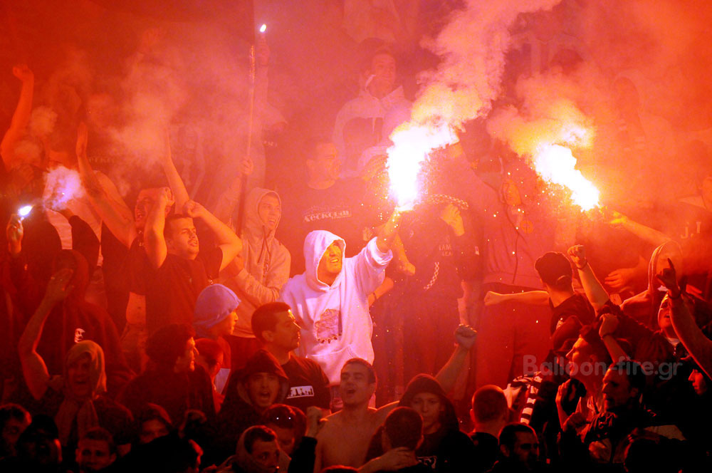Κόκκινα βεγγαλικά σε αγώνα ποδοσφαίρου με φιλάθλους